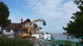 Demolition of clifftop home threatened by coastal erosion gets under way