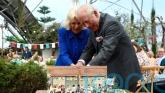 King and Queen share a giggle as they struggle to cut cake with sword