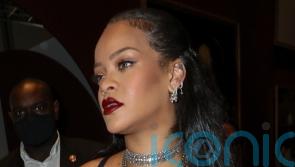 Rihanna cradles baby bump in sheer black dress at Dior show