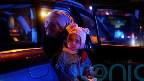 Mothers and young children queue to return to Ukraine at Polish train station