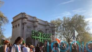 Two people climb Marble Arch amid protests against fossil fuels