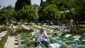 Sirens wail and people pause as Israel commemorates war dead