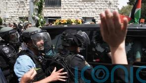 Coffin is dropped amid scuffles before Al Jazeera journalist is laid to rest