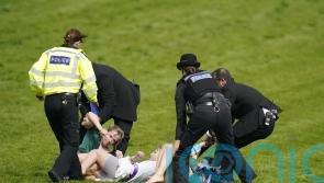 Animal activists taken away by police after running on to Epsom track