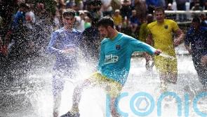 Annual river football clash goes ahead despite waterlogged pitch
