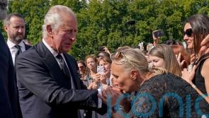 Cheers and kisses for the King as Charles greets well-wishers outside palace