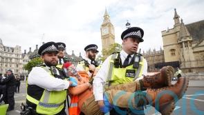 Police arrest activists who glued themselves to road outside Parliament