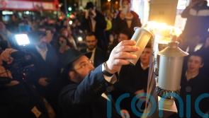 Group subjected to antisemitic attack return to scene to celebrate Hanukkah
