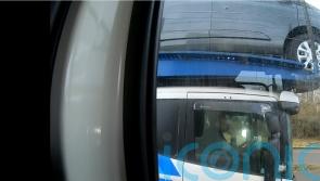 Driver caught using elbow to steer car transporter on motorway