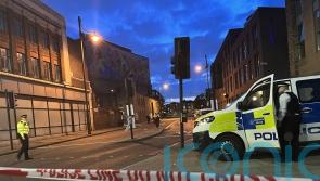 Relatives pray at police cordon after woman fatally stabbed in broad daylight