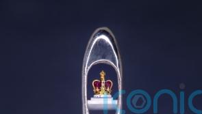 Sculptor creates tiny crown in the eye of a needle as coronation tribute