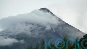 Rains unleashed by typhoon add to woes of thousands fleeing volcano