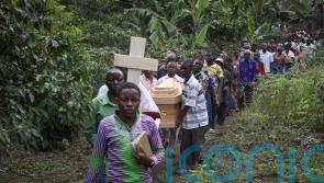 Victims are buried after rebel attack on Ugandan school leaves 42 dead