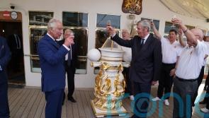 King enjoys tot of rum with former Royal Yacht Britannia sailors
