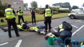 Climate protesters ‘concrete’ themselves to road to block refinery