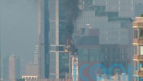 Pedestrians scatter as fire causes New York crane arm to crash to street