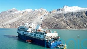Luxury cruise ship stranded off Greenland is pulled free at high tide