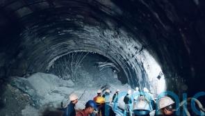 Rescuers dig to reach 40 workers trapped in collapsed road tunnel in India