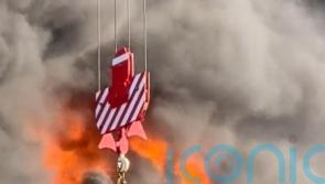 Workman trapped on burning high-rise building lifted to safety by crane