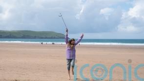 Beachgoers swap boogie boards for a boogie beach clean