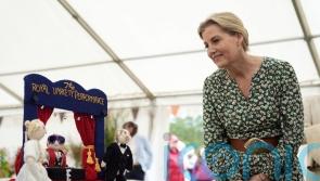 Sophie examines knitted versions of herself and husband at flower show