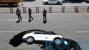 Driver and passenger injured as car is swallowed up by sinkhole