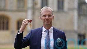 Former rugby referee Wayne Barnes jokes with William as he is made an OBE