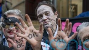 Climate activists in ‘zombie dance’ protest outside insurance offices