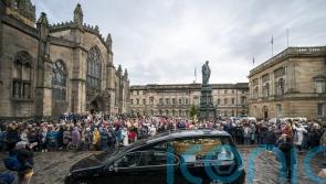 Hearse carrying coffin of Janey Godley showered with roses along Royal Mile