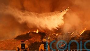 Firefighters race to contain LA wildfires as menacing winds forecast to return