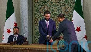 Syrian leader signs temporary constitution putting country under Islamist rule