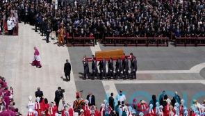 Quiet reverence and a ripple of applause for ‘the people’s pope’