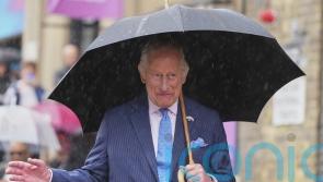 King visits London market after braving summer showers