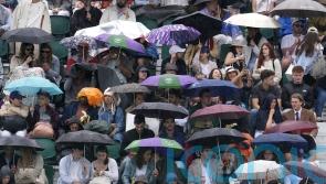 Spectators queue in ponchos as rain threatens to dampen sixth day of Wimbledon