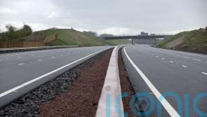 Travel disruption after lorry crash spills ‘shed load of wood’ on M8