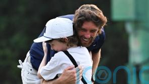 Tommy Fleetwood celebrates with son on 18th green after victory in Delhi