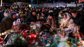 Mourners lay flowers as Swiss investigators probe fatal fire at ski resort bar