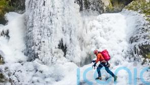Man scales frozen waterfall in national park amid &lsquo;very rare&rsquo; conditions