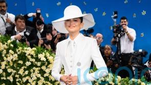 Zendaya sports gold band on her finger as she wears bridal white to fashion show