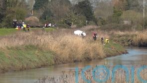 Divers recover body of teenage girl from river as search continues for male