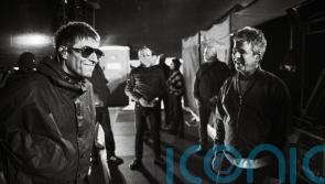 Liam and Noel Gallagher shown having a laugh in Oasis tour photography book