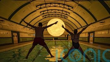 Sun artwork suspended above water at community swimming pool