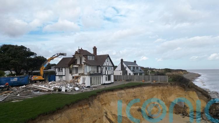 Demolition of fourth clifftop home at risk of falling into the sea begins