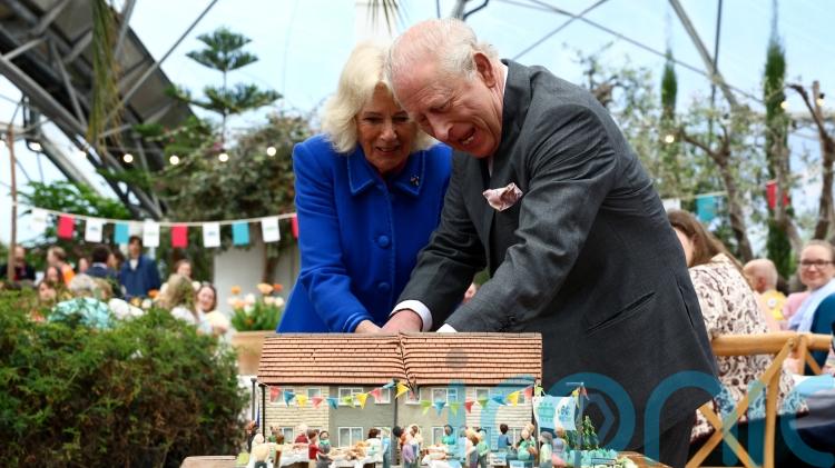 King and Queen share a giggle as they struggle to cut cake with sword