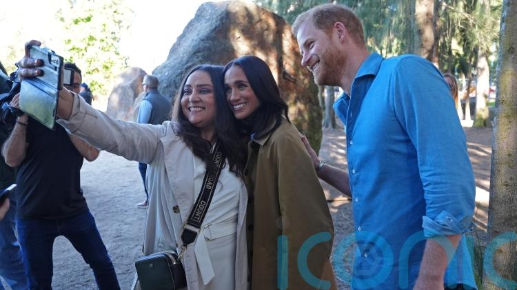 Harry and Meghan pose for selfies with public during walking tour