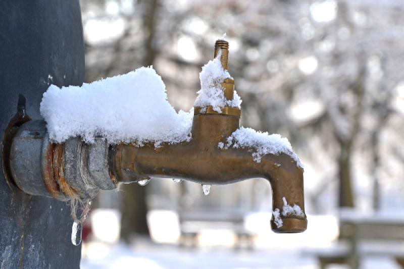 A public fountain with frozen tap
