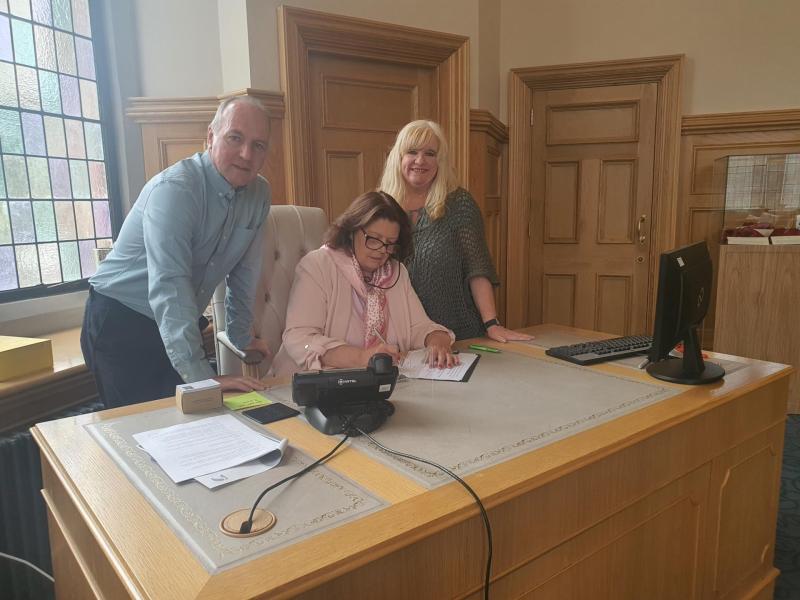 Tony Doherty and Maeve McLaughlin (BST) with Mayor Patricia Logue as she signs Pledge opposing Israeli Apartheid.