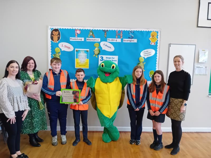 Karen Feeny (PDMU Co-ordinator), Lindsay McSparron (Barnardo's NI Programme Co-Ordinator) and Joanne O'Donnell (Principal) joined by some P7 B's Buddies and Twiggle to accept the award.