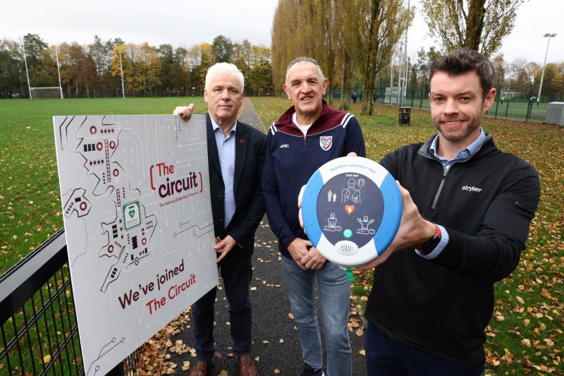John Deery (centre) from Eglinton survived a cardiac arrest at this year’s Belfast Marathon thanks to a life-saving defibrillator and CPR performed by Peter O’Hare (right holding the defib)