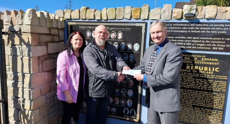 Martin Galvin (Ancient Order of Hibernians) presenting cheque to Kevin Hasson (Bogside Artist) at Creggan's Tribute Garden, with Catherine McBrearty.